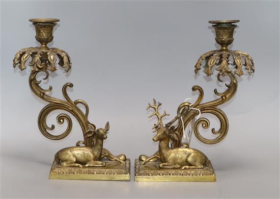 A pair of bronze candlesticks modelled as recumbent deer (lacking glass lustres) height 28cm